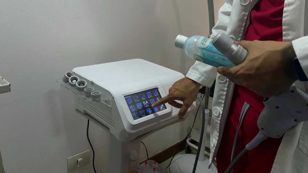 Médico usando un equipo de fisioterapia